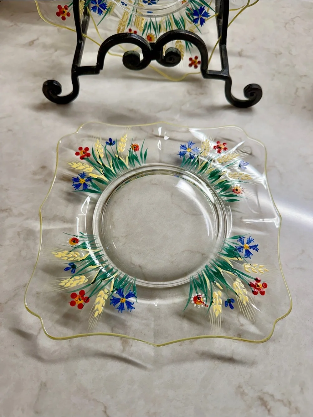 7 1/4” CLEAR GLASS PLATES WITH A COLORFUL, HAND-PAINTED DESIGN & YELLOW TRIM.